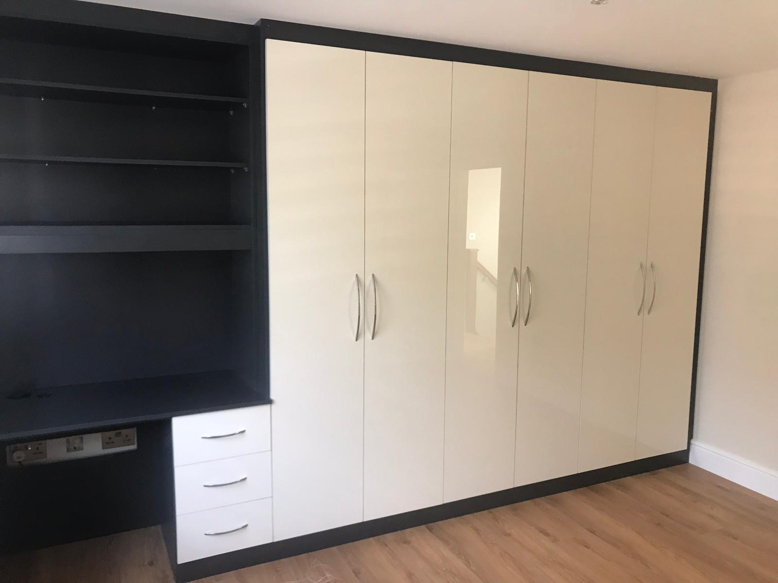 Bespoke fitted wardrobe utilizing a high gloss ultra-white and pebble black wood
